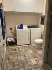 lower level bathroom with laundry and linen storag