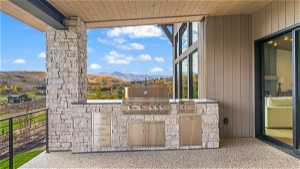 View of terrace with a balcony, grilling area, an outdoor kitchen, and a mountain view