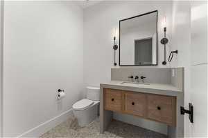 Bathroom featuring toilet, vanity, and tile floors