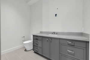 Bathroom featuring vanity, tile patterned flooring, and toilet