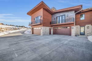 View of front of house featuring a balcony and a garage