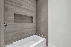 Bathroom with tiled shower / bath combo