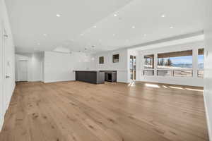 Unfurnished living room featuring sink and light hardwood / wood-style flooring