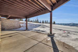 Snow covered patio with a mountain view