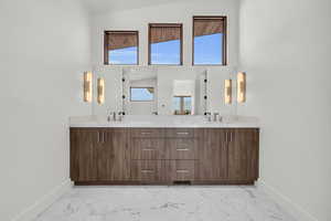 Bathroom with vanity and high vaulted ceiling