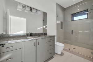 Bathroom with walk in shower, vanity, and toilet