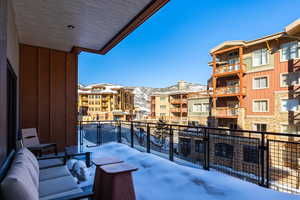 Snow covered back of property with a mountain view