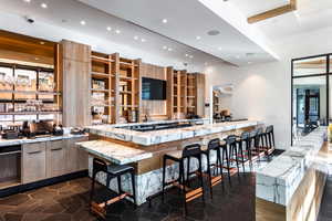 Bar with light stone counters and black dishwasher