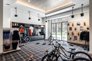 Workout area with carpet flooring, a high ceiling, and a tray ceiling