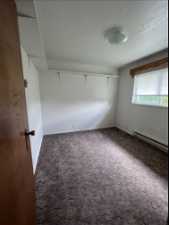 Spare room with a baseboard radiator, a textured ceiling, and carpet flooring