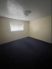 Spare room featuring carpet floors and a textured ceiling