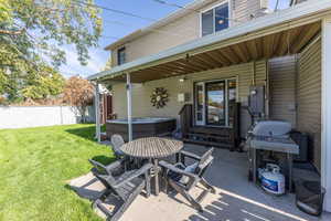 View of patio featuring area for grilling, central AC, and a hot tub