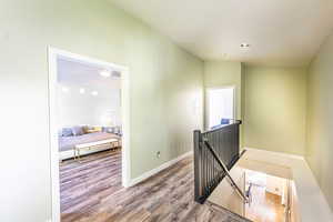 Hall with lofted ceiling and hardwood / wood-style flooring