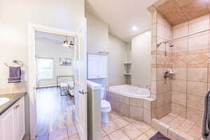 Full bathroom featuring hardwood / wood-style flooring, vanity, toilet, and separate shower and tub