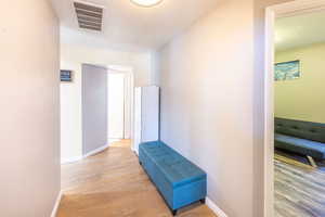 Hallway featuring a textured ceiling and light hardwood / wood-style floors