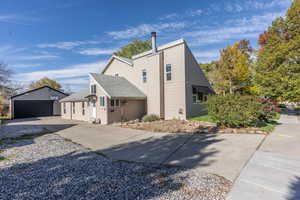 View of property exterior featuring an outbuilding and a garage