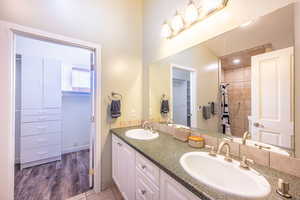 Bathroom with wood-type flooring, vanity, and curtained shower