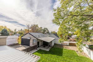 Rear view of property with a patio and a yard