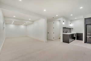 Kitchen with light colored carpet, sink, and tasteful backsplash