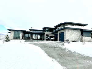 View of front of property featuring a heated driveway &  3 car garage