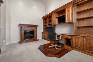 Unfurnished office with light carpet and built in desk