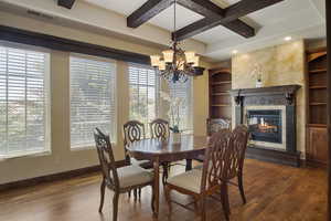 Dining area with coffered ceiling, beamed ceiling, and dark hardwood / wood-style flooring