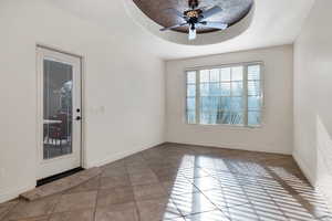 Semi-formal dining with ceiling fan and a raised ceiling and exterior patio entrance.