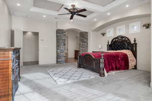 Bedroom featuring ornamental molding, coffered ceiling, ornate columns, and light colored carpet