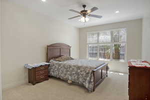 Guest bedroom with natural light and a ceiling fan