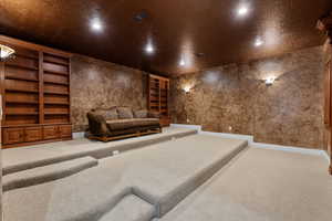 Carpeted home theater with recessed lighting and built in shelves