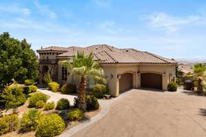 Mediterranean / spanish house featuring stucco siding, concrete driveway, stone siding, a garage, and a tiled roof