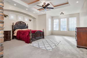 Bedroom featuring ceiling fan, coffered ceiling, light carpet, beamed ceiling, and crown molding