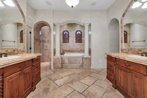 Bathroom with vanity, tiled tub, and ornate columns