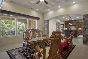 Living room featuring a ceiling fan, carpet, a breakfast bar, and natural light