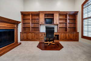 Carpeted home office with a wealth of natural light and built in desk