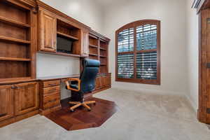 Carpeted home office with built in desk