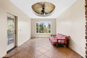 Living area with a ceiling fan, healthy amount of natural light, and tile patterned floors