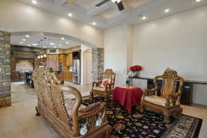 Interior space with coffered ceiling, ceiling fan, and beamed ceiling