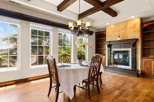 Dining room featuring light wood finished floors, a chandelier, recessed lighting, beam ceiling, and coffered ceiling