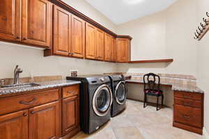 Washroom with cabinet space, separate washer and dryer, light tile patterned floors, and an office area