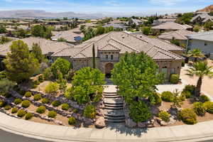 Mediterranean / spanish home featuring a tile roof, a residential view, stone siding, stucco siding, and a mountain view