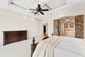 Bedroom with coffered ceiling, arched walkways, beamed ceiling, recessed lighting, and ensuite bath