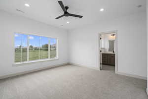 Carpeted bedroom featuring a ceiling fan and natural light