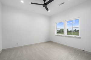 Carpeted spare room with natural light and a ceiling fan