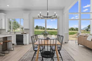 Wood floored dining area with a chandelier and natural light