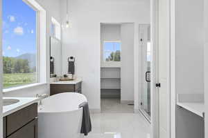 Bathroom featuring tile flooring, a wealth of natural light, separate shower and tub enclosures, mirror, and vanity