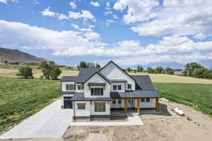 View of front of house featuring a front lawn and a mountain view