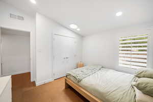 Bedroom with vaulted ceiling and carpet