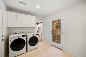 Washroom with tile floors and separate washer and dryer