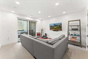 Carpeted living room with natural light and TV